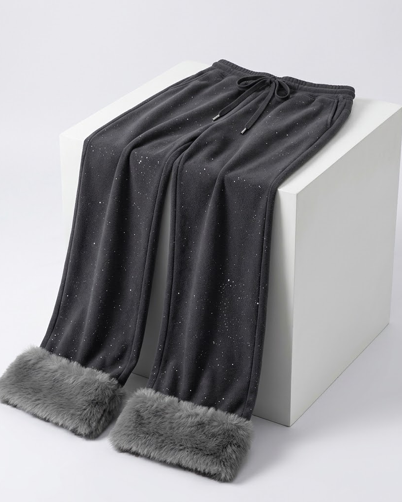 Dark grey wide-leg fur-cuff pants draped over a white block